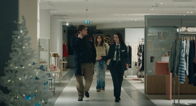 Nora im Kaufhaus, begleitet von ihrem Vater und einer Mitarbeiterin