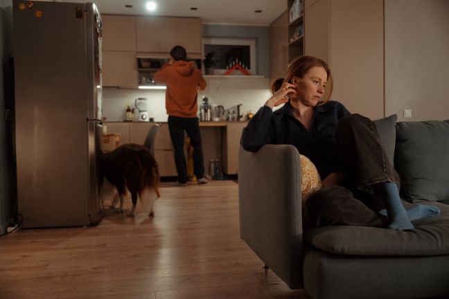 Zane sitzt auf der Couch, im Hintergrund Kaspars und der Hund