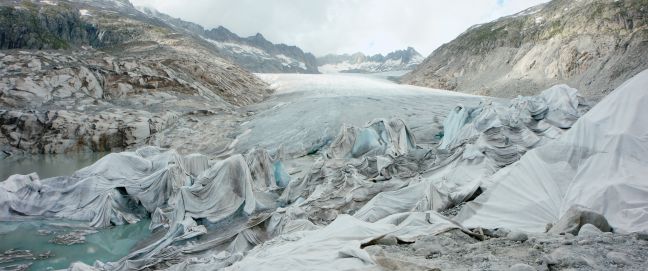 ein grauer Gletscher, teilweise mit weißen Tüchern verhangen