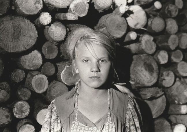 Ilse vor einem Holzstapel / schwarz-weiß