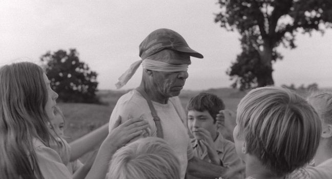 Karl-Göran wird mit verbundenen Augen von Kindern gedreht