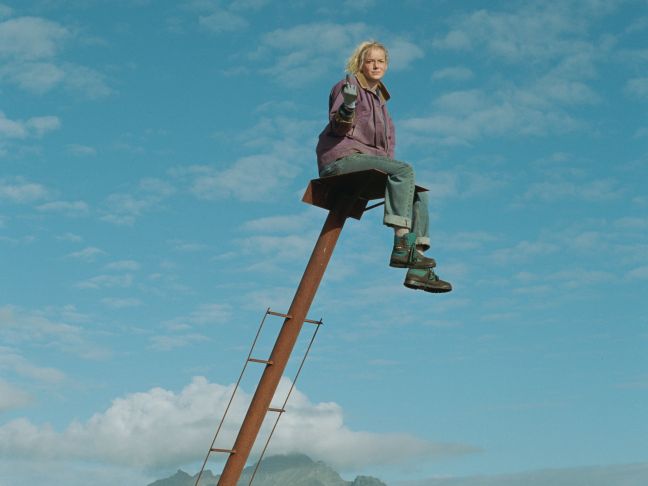 Anna ist auf einem Kran und zeigt den Mittelfinger