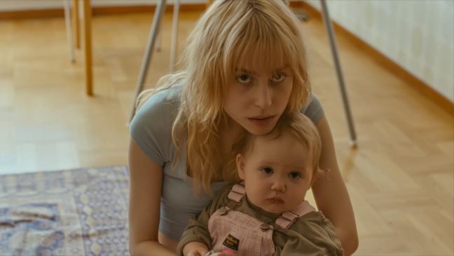 Esther stützt ihren Kopf auf ihre Tochter und schaut von unten in die Kamera