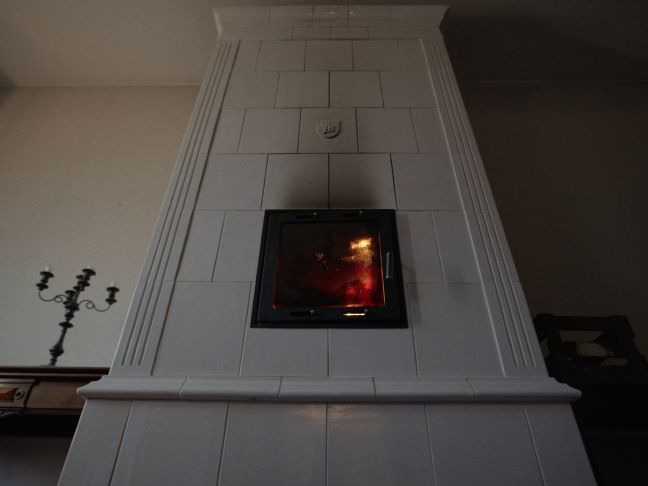 Ein weiß gekachelter brennender Ofen