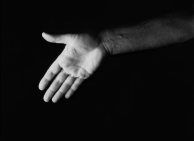 Eine beleuchtete Hand vor schwarzem Hintergrund