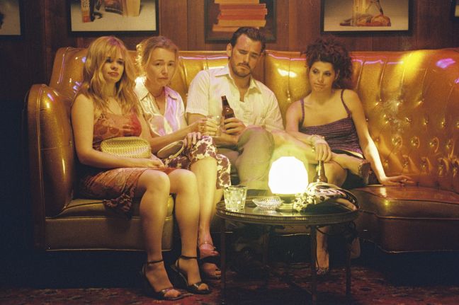 Hank und drei traurige Frauen sitzen auf einer Couch im Etablissement