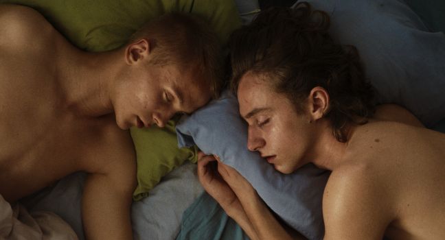 Alex und Robin schlafend mit freiem Oberkörper in einem Bett