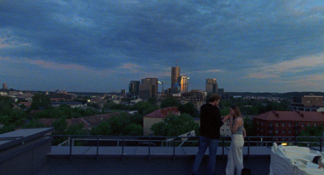 Ilona und Oleg rauchen auf dem Dach mit Blick auf die Skyline