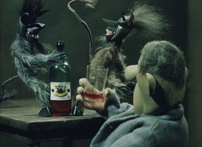 2 Teufelchen spielen mit der Alkoholflasche und tanzen auf dem Tisch