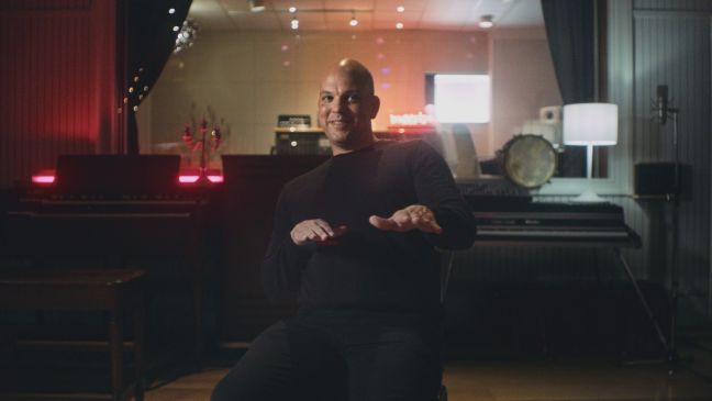 Quincy Jones III lehnt sich im Tonstudio auf dem Stuhl zurück und gestikuliert