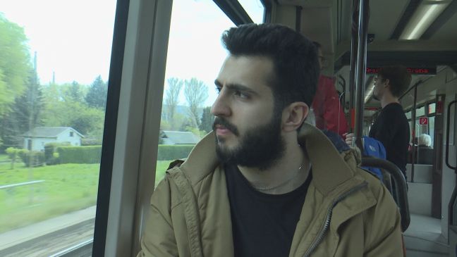 Alayham in Alltagskleidung im Zug, er schaut hinaus