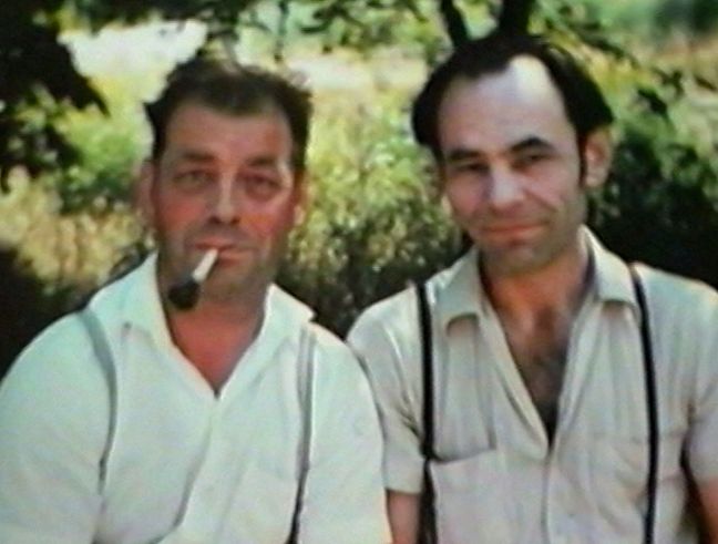 Zwei Männer posieren für das Foto, der linke hat eine Zigarette im Mund