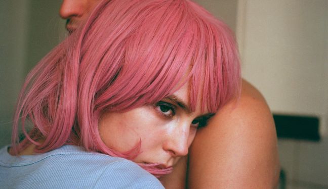 Esther schmiegt sich an die Schulter eines Mannes