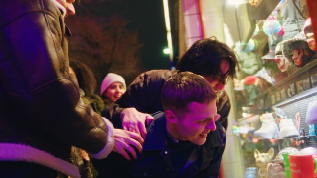 Samir mit Freunden nachts vor einem Schaufenster