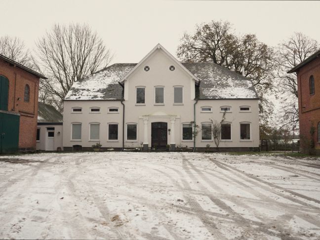 Das weiße Haupthaus des Hofes im Schnee