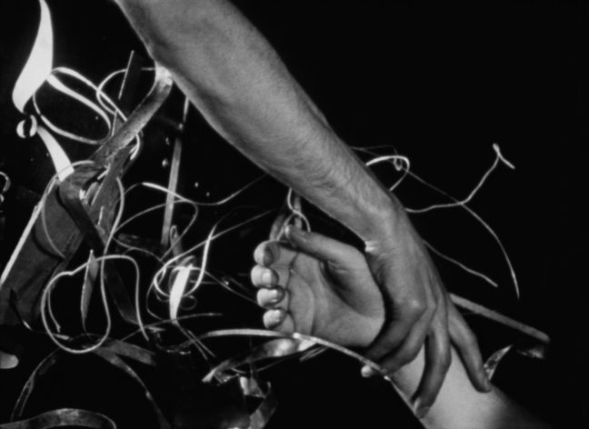 Zwei Hände berühren sich in einem Gewirr aus Drähten