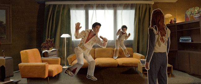 eine Frau von hinten und zwei Elvis-Figuren in einem Wohnzimmer
