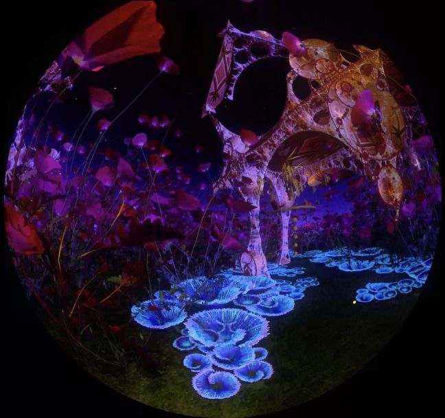 Im Dunkeln stehen bunte Bäume mit runden Löchern auf Rasen, gespickt von blauen Fächerblumen