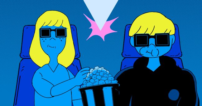 Junge und seine Mutter im Kino, sie essen Popcorn