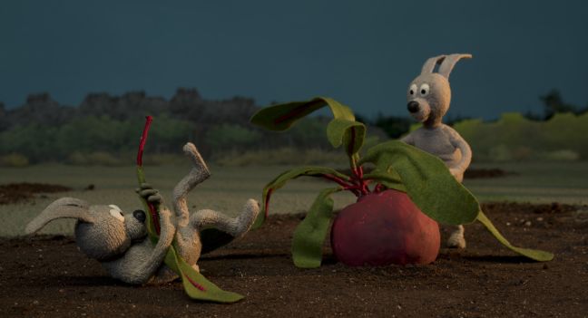 Zwei Hasen wollen ein Radieschen ernten, eins zieht an einem Blatt und fällt rückwärts hin, als es abreißt