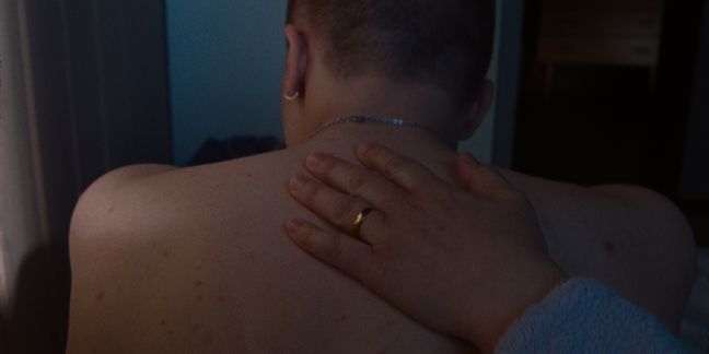 Emils Mutter legt ihre Hand auf seinen Rücken