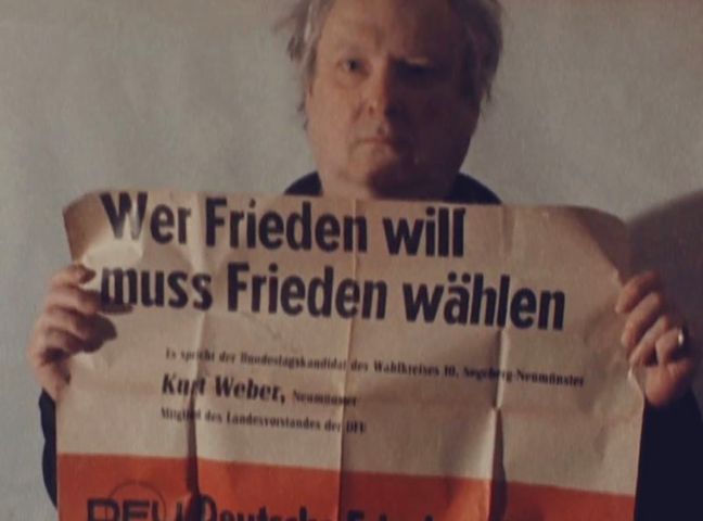 Kurt hält ein Plakat der DFU mit seinem Namen
