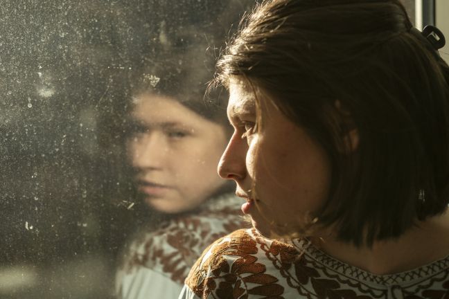 Luisa spiegelt sich in der Scheibe, die Sonne strahlt hindurch