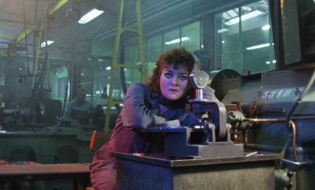 Eine Frau langweilt sich in der Fabrik