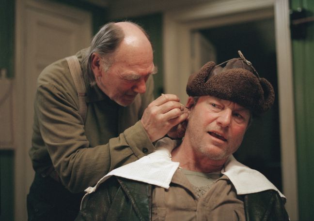 Isak will vorsichtig etwas dem Ohr von Grant holen