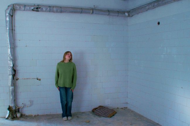 Elena vor einer gefliesten Wand