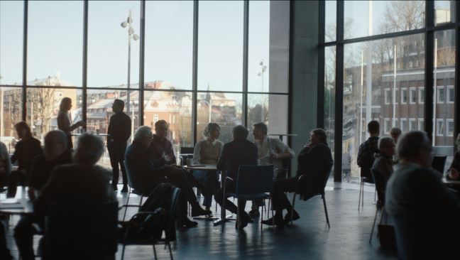 Der Cast sitzt in der Pause am Tisch und diskutiert