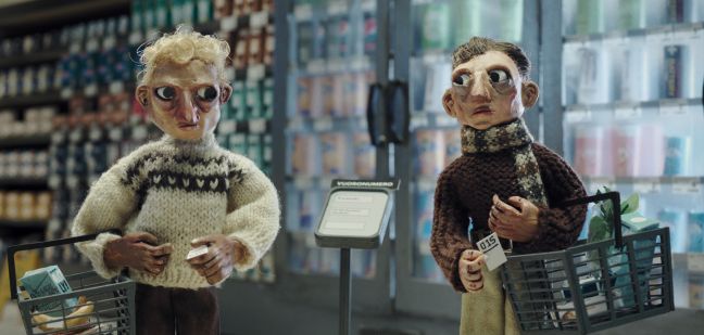 Zwei Menschen (Puppen) schauen sich beim Einkaufen schockiert an