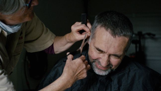 Carol schneidet Conny die Haare mit einer Schere