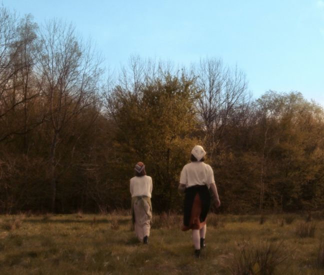 Sanna und Yva Kopmann gehen in traditioneller Kleidung zum Rotnaschibaum