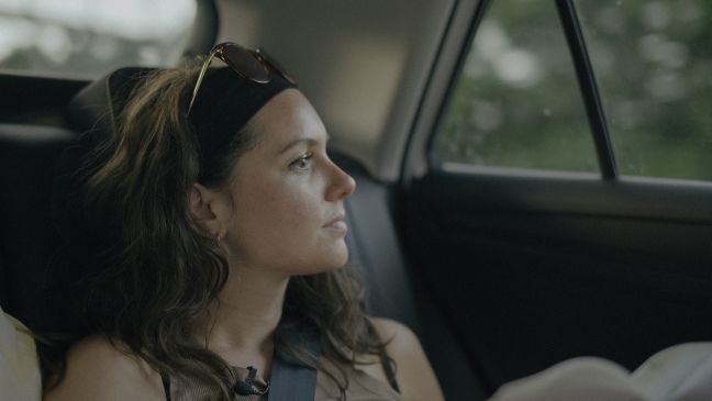 Alexandra sitzt im Auto und guckt aus dem Fenster