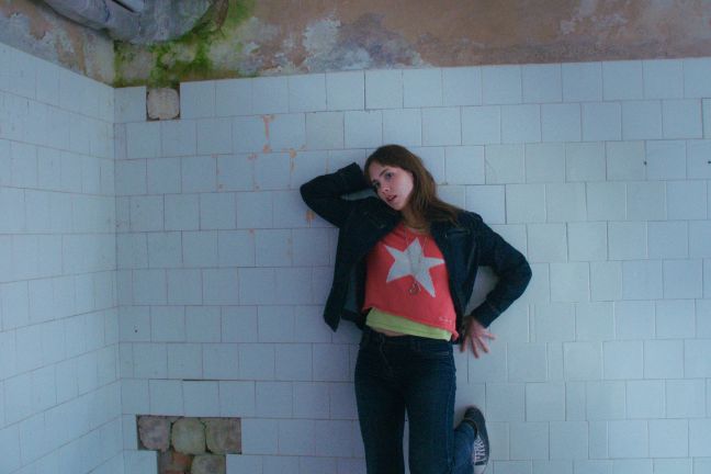 Laura posiert vor einer gefliesten Wand