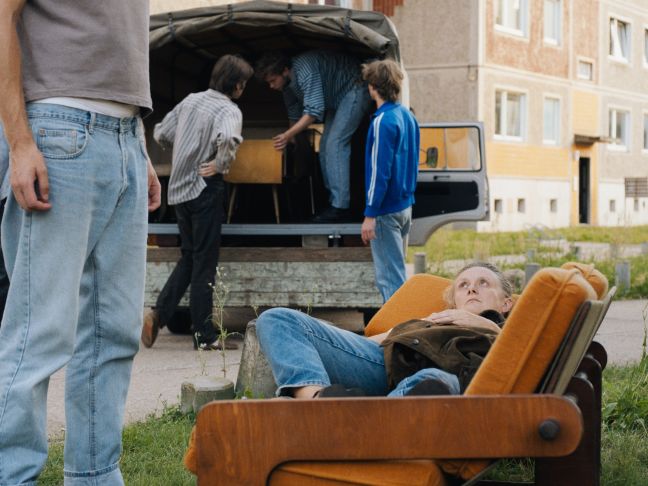 Ein Umzug findet statt, Patty liegt auf einem Sofa, das auf der Straße steht
