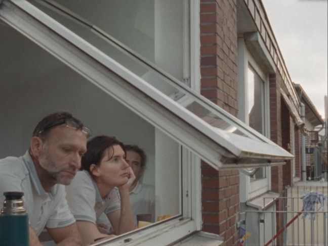Rike und zwei Kollegen schauen aus einem Dachfenster